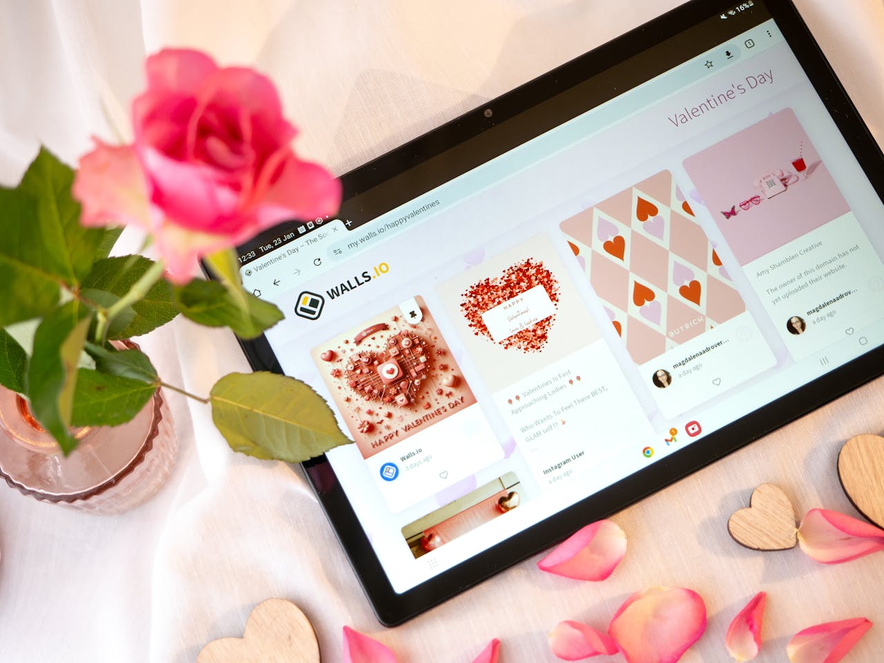 A romantic arrangement with a rose and a tablet displaying Valentines Day themes. Perfect for romantic or tech-related content.